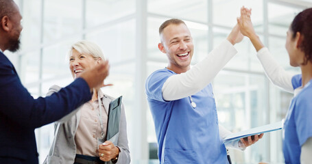 Obraz premium Doctors, high five and celebration with team at clinic for breakthrough, progress and medical solution. People, men and women with cheers, success and goals for healthcare innovation at hospital