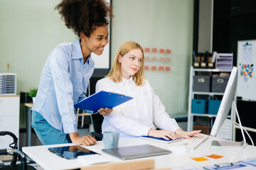 Businesswoman leading team meeting and using tablet and laptop computer with financial