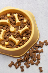 Dry dog food in slow feeder bowl preventing gulping
