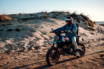 Obraz premium Man on motorcycle at sandy beach