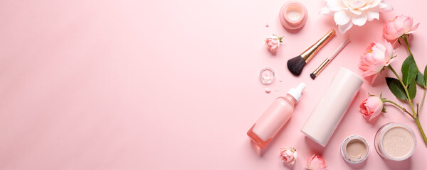 Beauty products and flowers arranged on a soft pink background showcasing an elegant and serene atmosphere