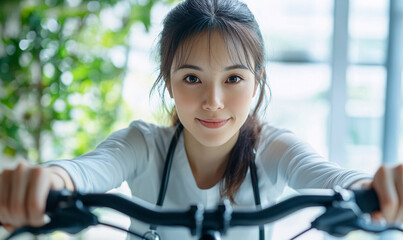 Obraz premium Engaging cycling activity with a young woman indoor gym lifestyle photography bright environment