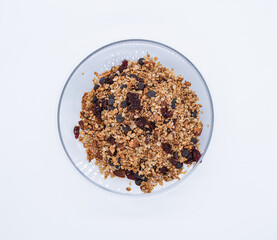 Delicious healthy granola in a glass bowl with cranberries and chocolate