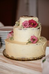 Three-tiered wedding cake with pink roses.