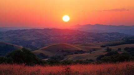 Serene sunset over rolling hills with vibrant colors and silhouetted landscape in the background
