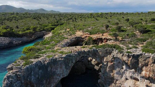 Experience breathtaking landscapes of Cala Varques in Porto Cristo, showcasing rugged cliffs surrounded by turquoise waters and vibrant greenery. Perfect for nature enthusiasts.