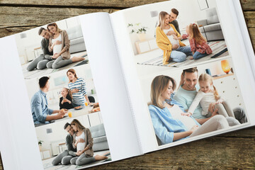 Different photos in open photo album on wooden table, top view