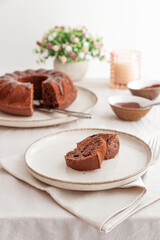 Chocolate cake with chocolate icing on white wooden table. Front view
