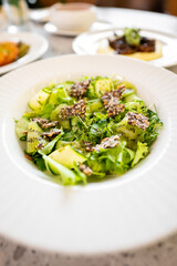A fresh, vibrant salad featuring mixed greens, diced kiwi, and a sprinkle of sesame seeds. Perfect for healthy eating and showcasing colorful, nutritious dishes in culinary contexts.