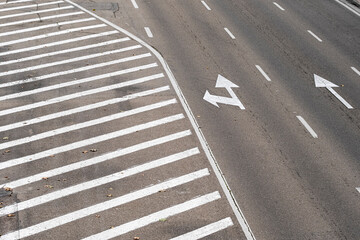 Curved highway lanes with directional arrows and clear road markings in an urban setting.