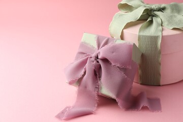 Different gift boxes with beautiful bows on pink background. Space for text