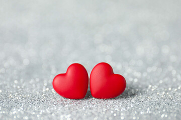 Fototapeta premium Red decorative hearts on shiny silver background. Happy Valentine's day