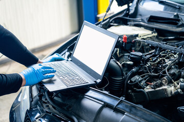 Serviceman with laptop checks car software in car service