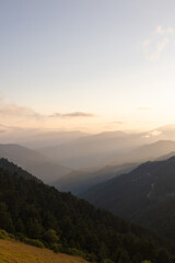 Layered mountains with haze at sunset.