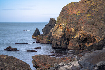 Breathtaking view of Valahnúkamöl Bay with steep cliffs and lava rocks in southern Iceland