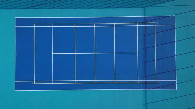 multifunctional outdoor playground for ball games at school. green artificial turf from a plastic carpet with lines. basketball hoops and soccer goals. around the grabbing high net and guardrails 