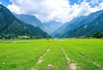 Obraz premium Serene Green Valley: Majestic Mountain Range and Tranquil Pasture Landscape