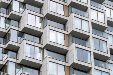 Abstract facade of modern apartments with cubic balconies and geometric patterns in London.
