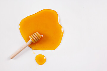 honey spoon with spilled honey on white background, top view