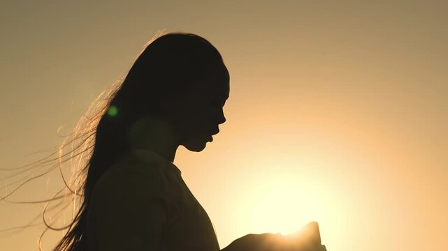 girl prays with bible her hands sunset. young girl asks for help. read prayer dawn. human faith dream. ask sky. relaxation concept. happy person lives faith. good book helps find way. pray park sunset