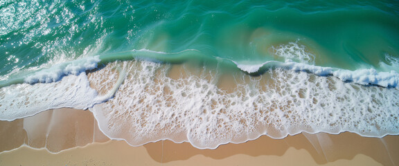 Fototapeta premium Aerial view of turquoise waves crashing on sandy beach, serene escape