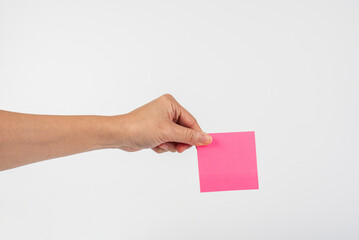 Paper stickers in hand. Hand holding a green sticker. Notes for the message.