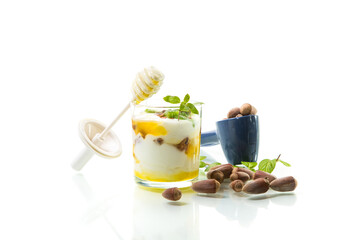 homemade yogurt with kiwi, honey and nuts in a glass, isolated on white background
