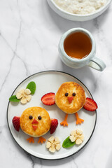 A plate of two small pastries with strawberries and bananas on top
