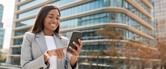 Mature smiling successful African American business woman entrepreneur working on mobile phone...