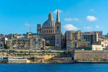 Fototapeta premium Valletta skyline with the St. Pauls Cathedral and sailboats in the Marsamxett Harbour in Valletta, Malta.