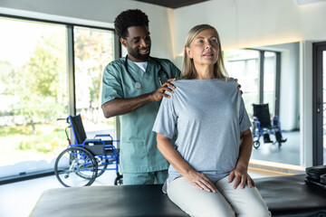 Fototapeta premium African american male doctor working on correction of female patients posture
