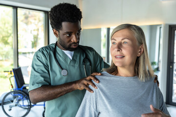 Obraz premium African american male doctor working on correction of female patients posture