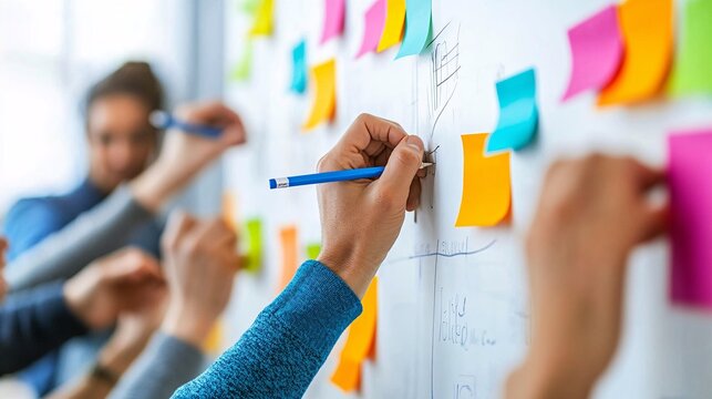 Hands Engaging in Collaborative Sticky Note Brainstorming Session