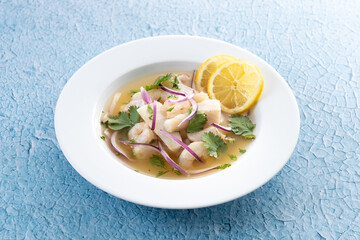 Traditional Peruvian ceviche sea bass fillet on blue background