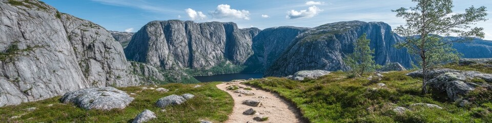 Scenic Hiking Path Through Rugged Mountains With Lush Greenery and Serene Lake Under Blue Sky