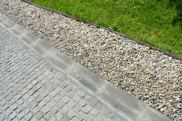 A detailed close-up shot of a modern French drain system, showcasing the gravel-filled trench...