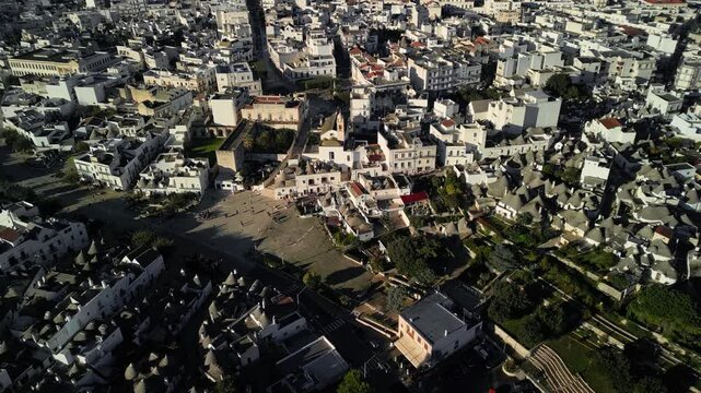 Flight over the center of Alberobello. The city is famous for the amazing architecture of the Truli houses. Alberobello is visited by millions of tourists a year. Sunset over Truli.