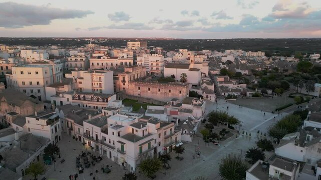 flight over the center of Alberobello. city is famous not only for amazing architecture of the Truli houses, but also for true architecture of Italy. white houses with tiled roofs in the setting sun