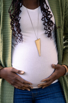A pregnant woman holding her belly, pregnancy