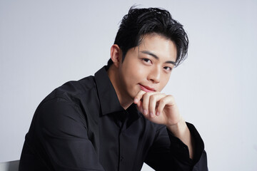 メイクアップをした黒いシャツを着た若い男性のスタイリッシュなポートレート