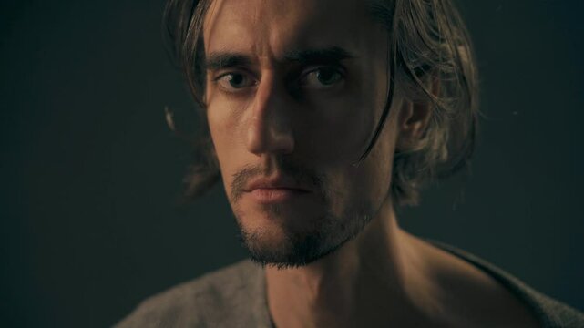 Emotional Guy Close-Up Young man with big eyes and long hair in a close-up shot showing tears and deep emotion