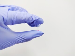 scientist holding microtube containing red solution