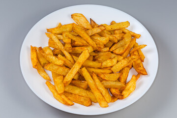 French fries on white dish on a gray background