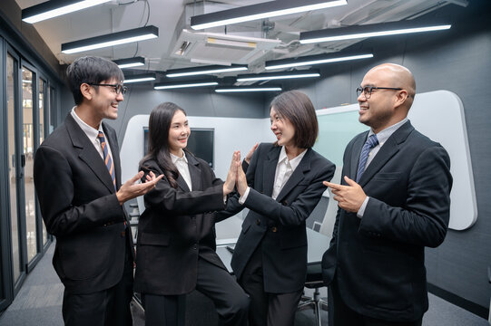 Business people, men and women, standing, posing, meeting in office, with documents, laptops and brainstorming, planning sales, digital marketing and growth strategies with colorful charts and graphs.