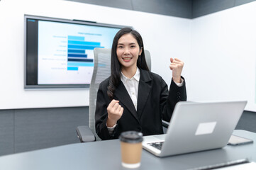 Beautiful young businesswoman in a meeting in a modern office, focused on documents, laptop and a...