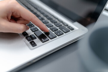 Finger shot of businesswoman pressing button to enter sales plan on computer. Digital marketing, growth strategy, marketing goals, analysis with colorful charts and graphs.
