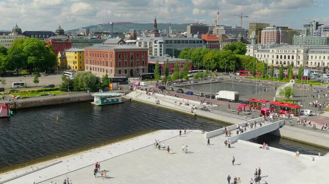 Panoramablick vom Opernhaus in Oslo auf den gesch&auml;ftigen Hafen &ndash; Moderne Architektur trifft auf maritimes Treiben mit Schiffen, Kr&auml;nen und urbaner Skyline in Norwegens Hauptstadt