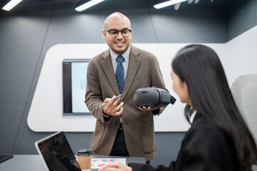 Male software developer, VR glasses system meeting in office with documents, laptop, sales...