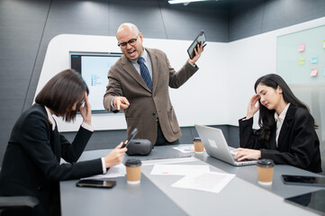 Male software developer meeting in modern office with stressed employees, documents, laptops, sales planning, digital marketing and growth strategies, analysis with colorful charts and graphs.