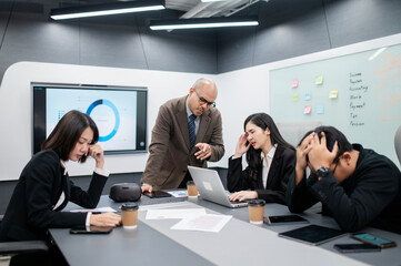 Male software developer meeting in modern office with stressed employees, documents, laptops, sales planning, digital marketing and growth strategies, analysis with colorful charts and graphs.